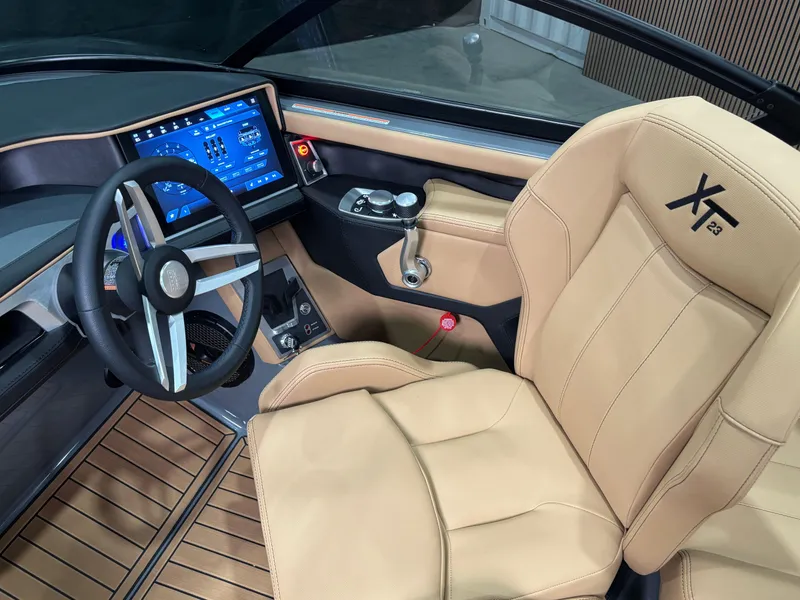 Slide: The Image of 2025 MasterCraft XT23 boat interior with tan leather seats and modern dashboard display. - 9