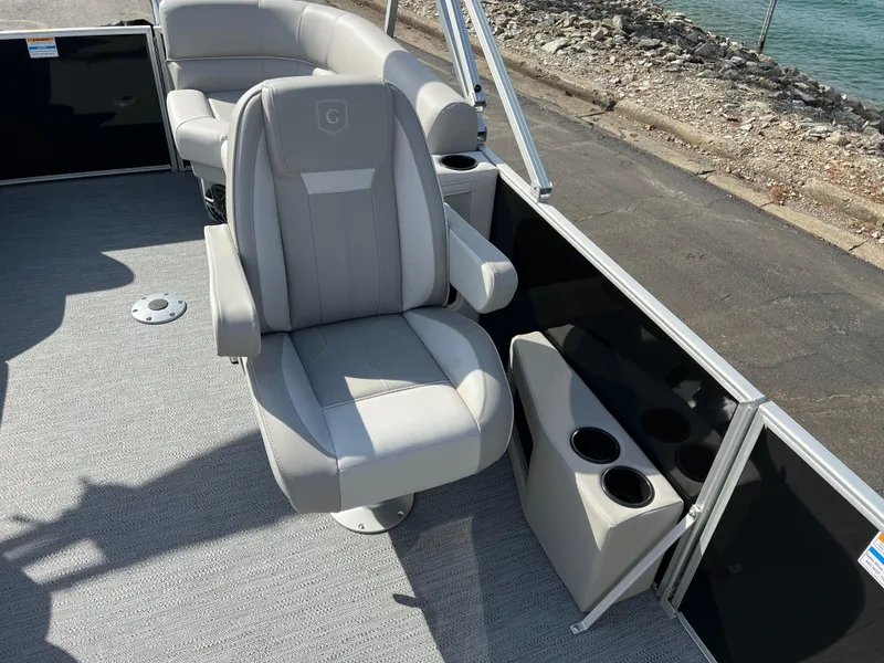 Slide: The Image of 2025 Godfrey Xperience Split Bench boat interior with gray seating and cup holders. - 11