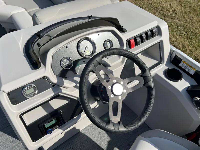Slide: The Image of 2025 Godfrey Xperience Split Bench boat dashboard with steering wheel and gauges. - 17