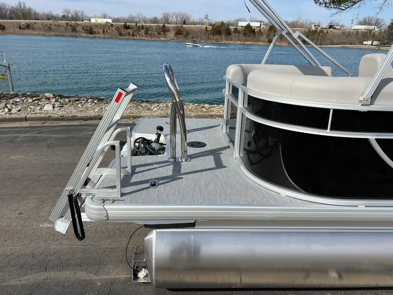 Slide: The Image of 2025 Godfrey Xperience Split Bench pontoon boat docked by a serene lake. - 5