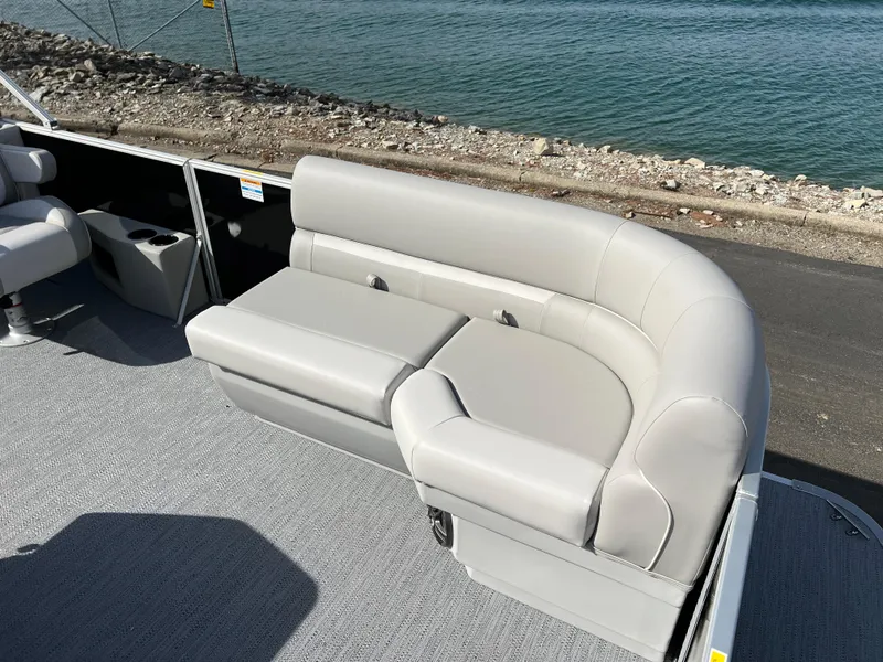 Slide: The Image of 2025 Godfrey Xperience Split Bench on a boat, near water and rocky shoreline. - 9