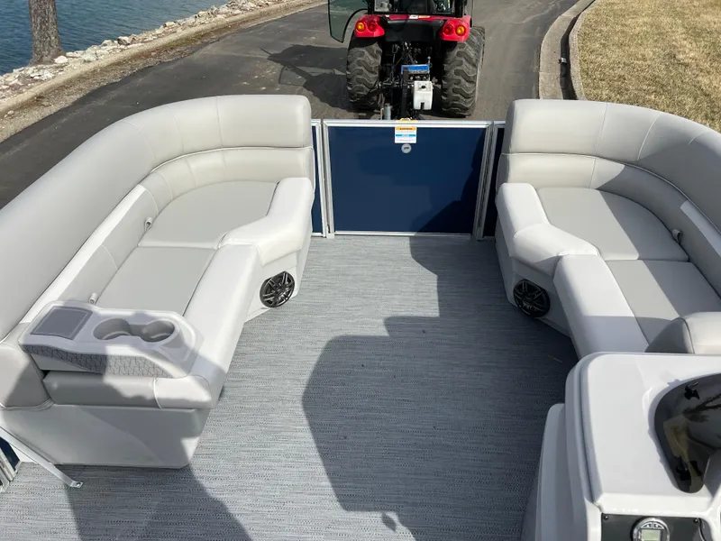 Slide: The Image of 2025 Godfrey Xperience Split Bench boat interior with gray seating and cup holders. - 16