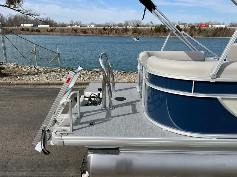 Slide: The Image of 2025 Godfrey Xperience Split Bench pontoon boat by a lake, featuring sleek design and comfortable seating. - 5