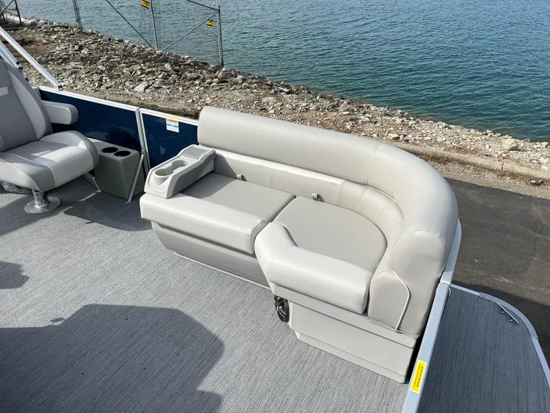 Slide: The Image of 2025 Godfrey Xperience Split Bench on boat, featuring sleek gray upholstery by the water. - 8