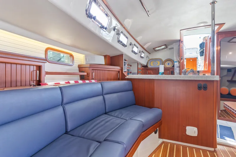 Slide: The Image of Interior of 2015 Blue Jacket 40 sailboat with blue seating and wooden accents. - 16