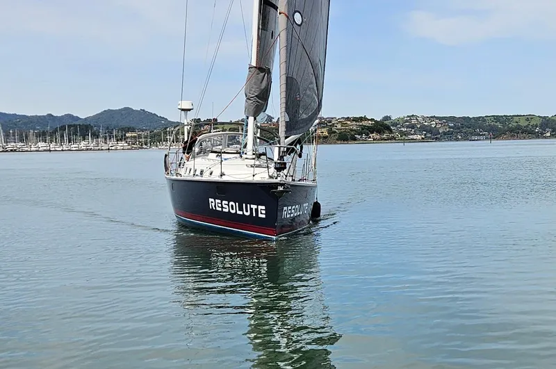 Slide: The Image of Sailboat "Resolute" on calm water, Blue Jacket 40 model, 2015, with scenic background. - 4