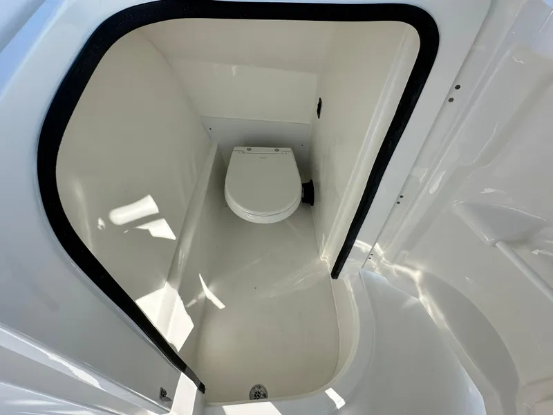 Slide: The Image of 2025 Sea Pro 240 Dual Console boat interior with compact marine toilet. - 12