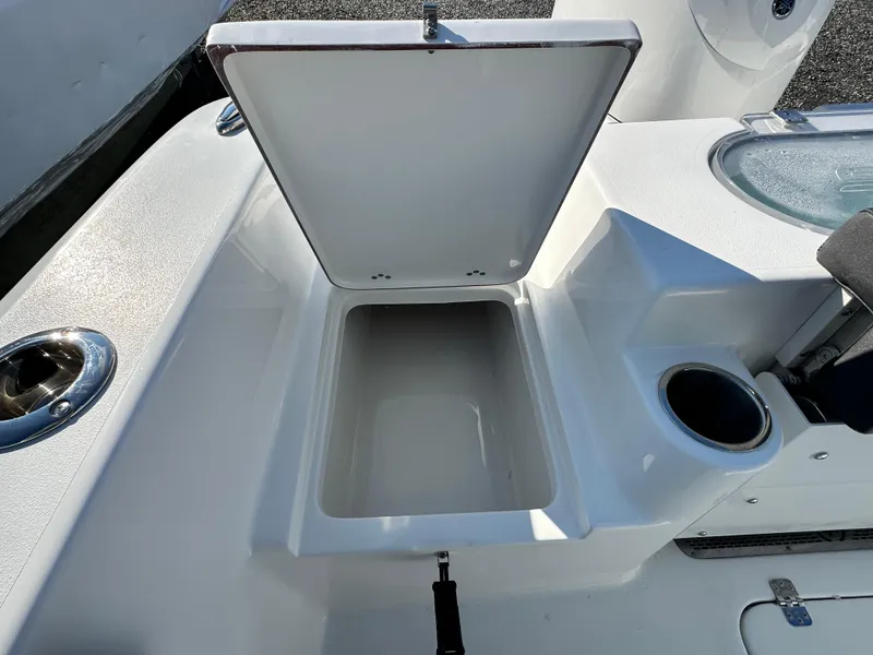 Slide: The Image of 2025 Sea Pro 240 Dual Console boat with open storage compartment and cup holder. - 21