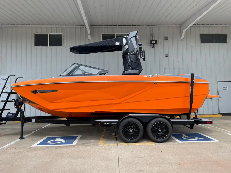 Slide: The Image of 2023 Nautique Super Air Nautique G21 boat in vibrant orange on trailer. - 1