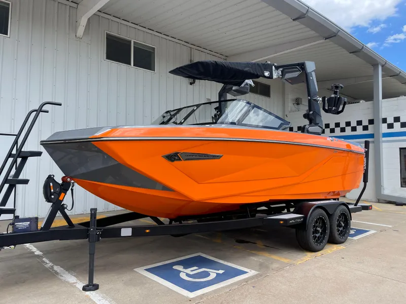 Slide: The Image of 2023 Nautique Super Air Nautique G21 boat in vibrant orange on a trailer. - 2