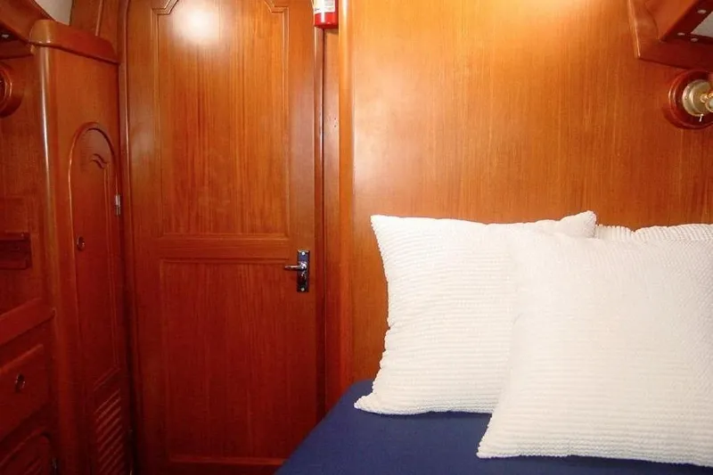 Slide: The Image of Cozy cabin interior of 1986 Mason 33 yacht with wooden paneling and white pillows. - 10