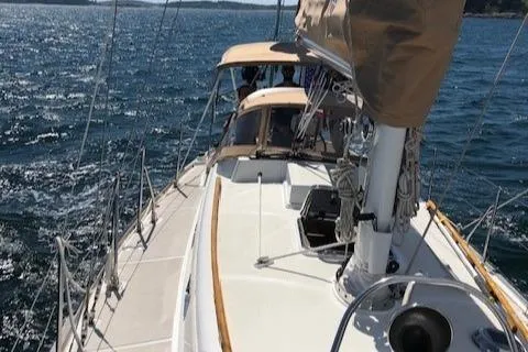 Slide: The Image of 1986 Mason 33 sailboat cruising on open water. - 14