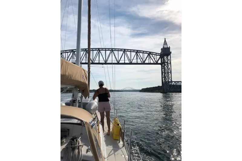 Slide: The Image of Sailboat Mason 33 (1986) passing under a bridge on a sunny day. - 20