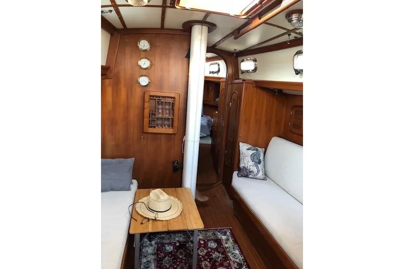 Slide: The Image of Cozy 1986 Mason 33 yacht interior with wooden decor and seating area. - 22