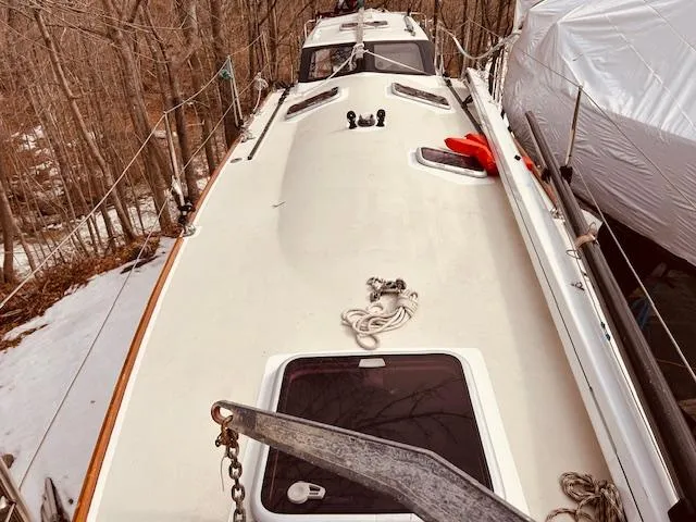 Slide: The Image of 2006 Robert Perry Far Harbour 39 sailboat deck with anchor and ropes in a wooded area. - 8