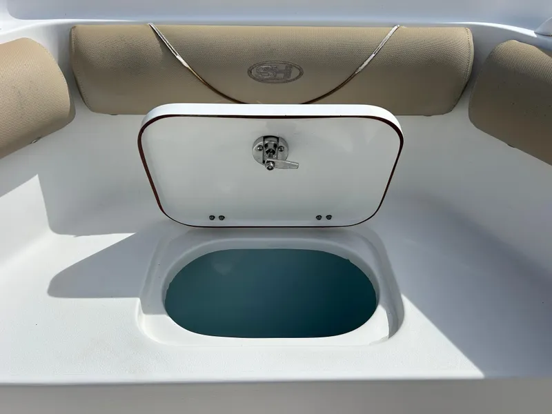 Slide: The Image of 2015 Sea Hunt Gamefish 30 boat with open storage compartment and cushioned seating. - 19