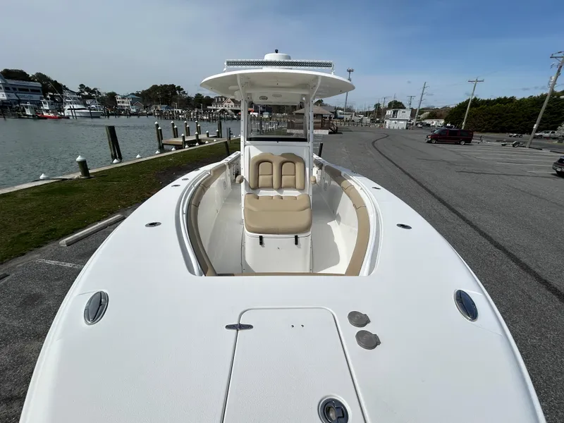 Slide: The Image of 2015 Sea Hunt Gamefish 30 with Coffin Box, docked near a marina, showcasing spacious deck. - 21