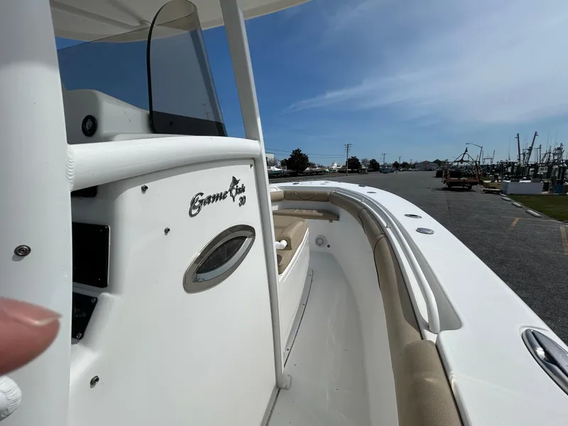 Slide: The Image of 2015 Sea Hunt Gamefish 30 boat with coffin box, docked under clear blue sky. - 23