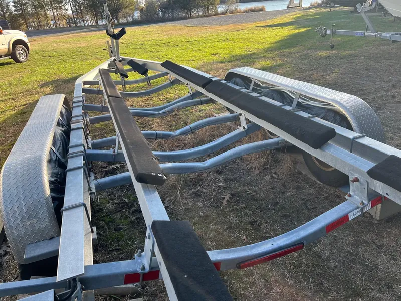 Slide: The Image of Boat trailer for 2015 Sea Hunt Gamefish 30, parked on grass near water. - 31