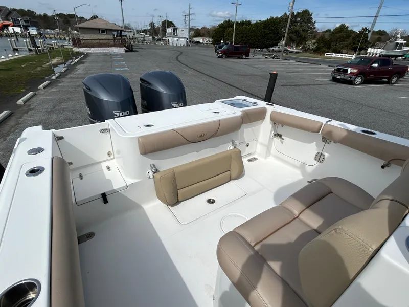 Slide: The Image of 2015 Sea Hunt Gamefish 30 boat interior with seating and twin engines in a parking area. - 8