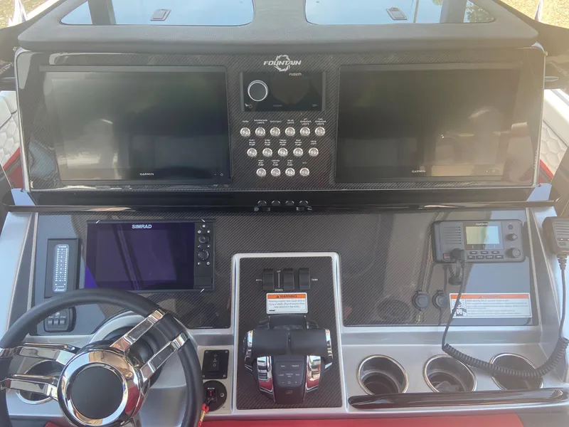Slide: The Image of 2022 Fountain 38 SC boat dashboard with steering wheel, controls, and navigation screens. - 11