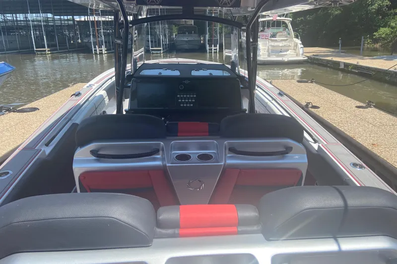 Slide: The Image of 2022 Fountain 38 SC boat interior with red and black seating at a dock. - 18