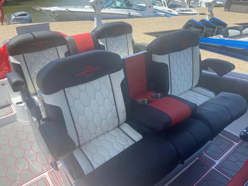 Slide: The Image of 2022 Fountain 38 SC boat seats with black and white upholstery, red accents, and cup holders. - 19