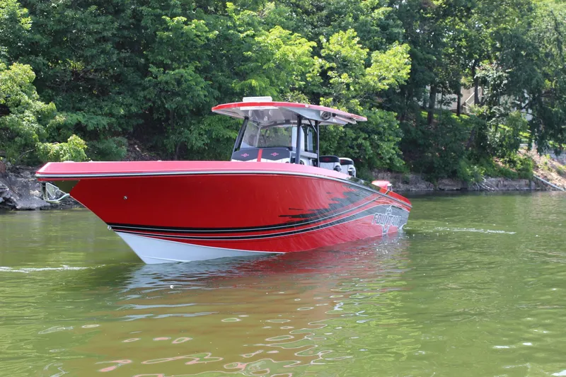 Slide: The Image of Red 2022 Fountain 38 SC boat on a calm lake with lush green trees. - 5