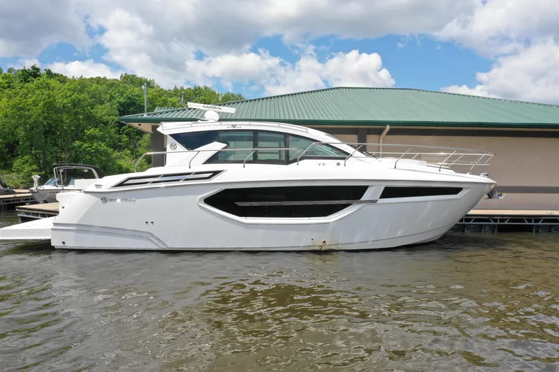 Slide: The Image of 2019 Cruisers Yachts 42 Cantius docked, sleek white design, under cloudy sky. - 0