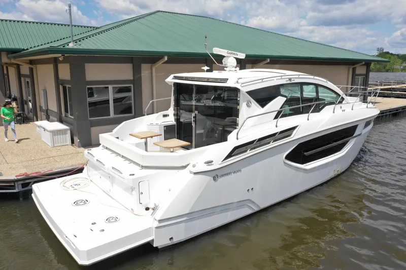 Slide: The Image of 2019 Cruisers Yachts 42 Cantius docked by a marina under a clear sky. - 3