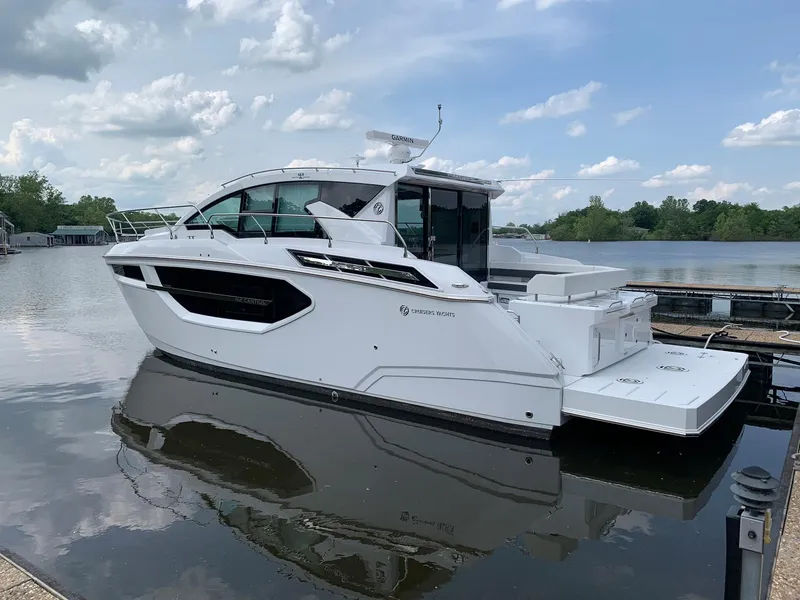 Slide: The Image of 2019 Cruisers Yachts 42 Cantius docked on a calm river under a cloudy sky. - 5