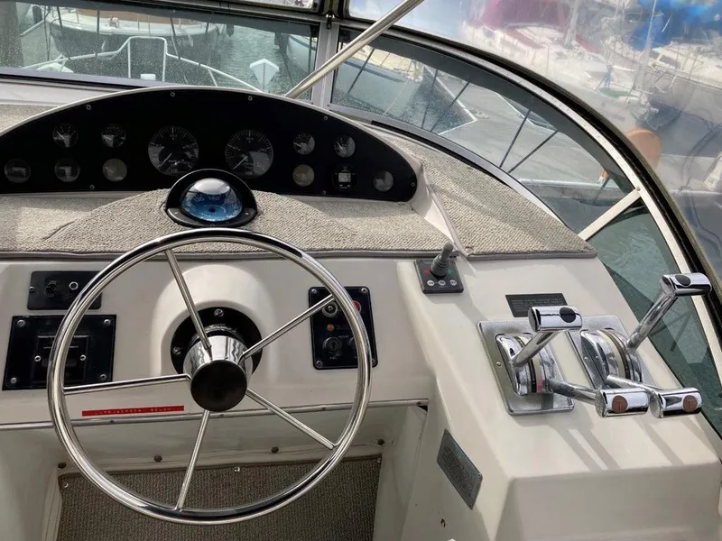 Slide: The Image of 1996 Bayliner 3788 Command Bridge Motoryacht helm with steering wheel and control panel. - 13