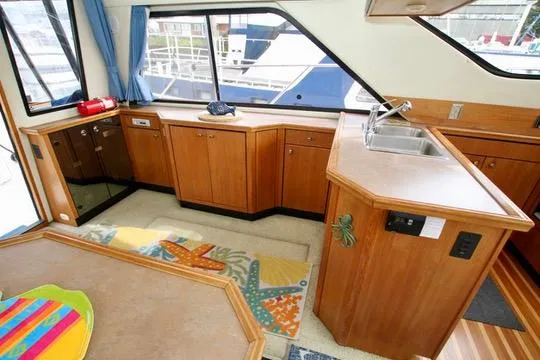 Slide: The Image of Interior of 1996 Bayliner 3788 Command Bridge Motoryacht with wooden cabinetry and colorful rug. - 19