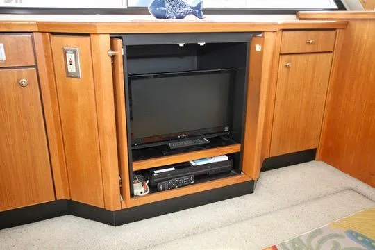 Slide: The Image of 1996 Bayliner 3788 Command Bridge Motoryacht interior with built-in TV and wooden cabinetry. - 21