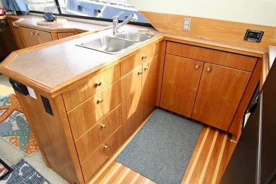 Slide: The Image of 1996 Bayliner 3788 Command Bridge Motoryacht kitchen with wooden cabinets and stainless steel sink. - 24