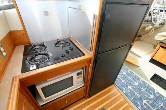 Slide: The Image of Compact kitchen in 1996 Bayliner 3788 yacht with stove, microwave, and fridge. - 26