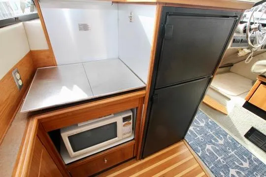 Slide: The Image of Interior of 1996 Bayliner 3788 yacht kitchen with microwave and fridge. - 27