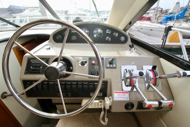Slide: The Image of 1996 Bayliner 3788 Command Bridge Motoryacht helm with steering wheel and controls. - 32
