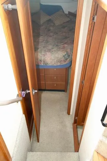 Slide: The Image of Interior view of 1996 Bayliner 3788 Command Bridge Motoryacht bedroom with wooden doors and carpeted floor. - 34