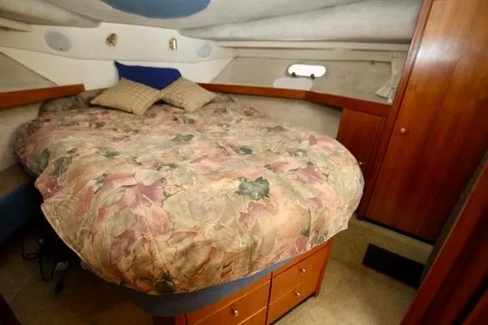 Slide: The Image of 1996 Bayliner 3788 Command Bridge Motoryacht cabin with floral bedding and wooden cabinetry. - 36