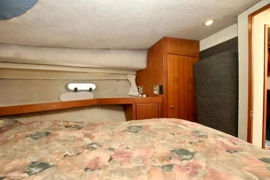 Slide: The Image of 1996 Bayliner 3788 Command Bridge Motoryacht cabin interior with floral bedding and wooden cabinetry. - 38