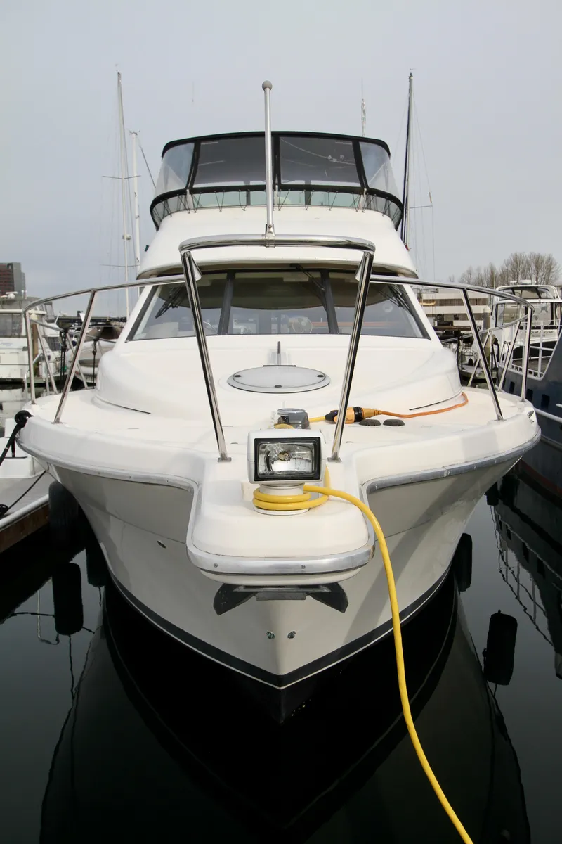 Slide: The Image of 1996 Bayliner 3788 Command Bridge Motoryacht docked, front view with yellow power cable. - 4