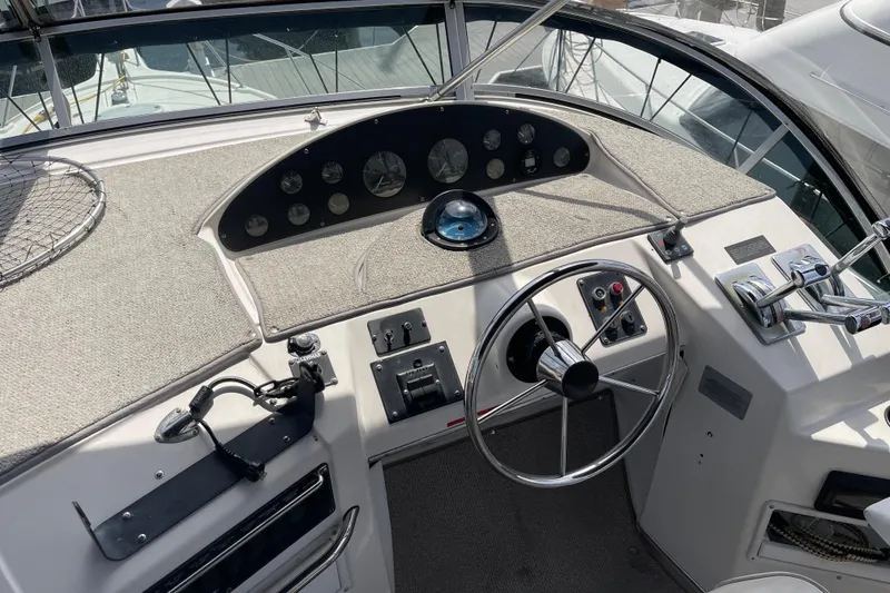 Slide: The Image of 1996 Bayliner 3788 Command Bridge Motoryacht helm with steering wheel and control panel. - 52