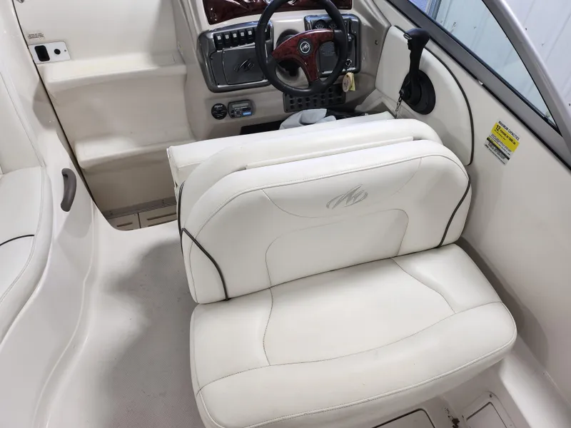 Slide: The Image of Interior of a 2007 Monterey 250 Cruiser boat with white seating and steering wheel. - 13