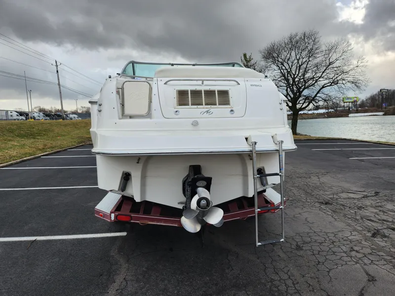 Slide: The Image of 2007 Monterey 250 Cruiser boat parked near a lake under cloudy skies. - 2