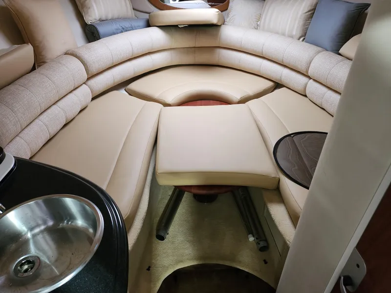 Slide: The Image of Interior of a 2007 Monterey 250 Cruiser boat with beige seating and a small sink. - 27