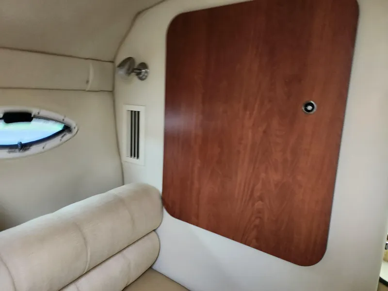 Slide: The Image of Interior of a 2007 Monterey 250 Cruiser, featuring a wooden cabinet and beige seating. - 29