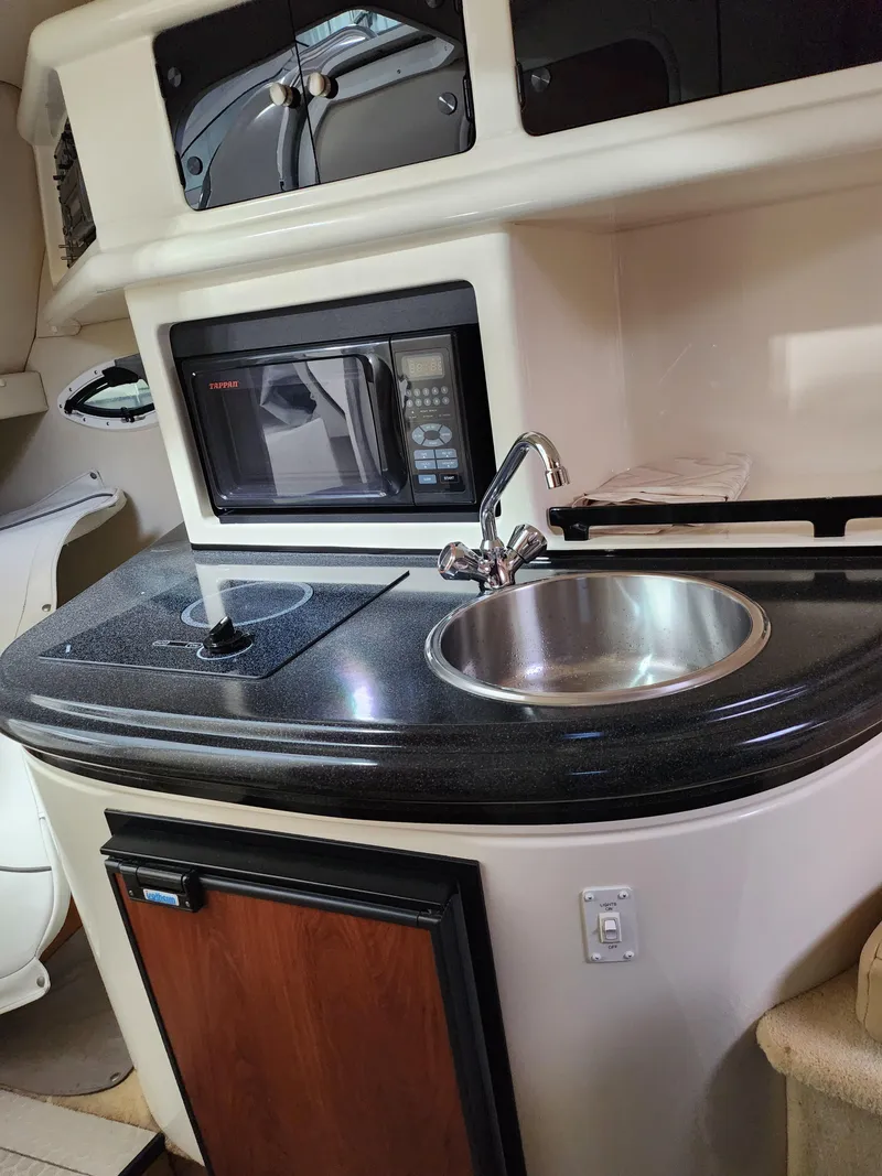Slide: The Image of 2007 Monterey 250 Cruiser kitchenette with sink, microwave, and stove. - 33