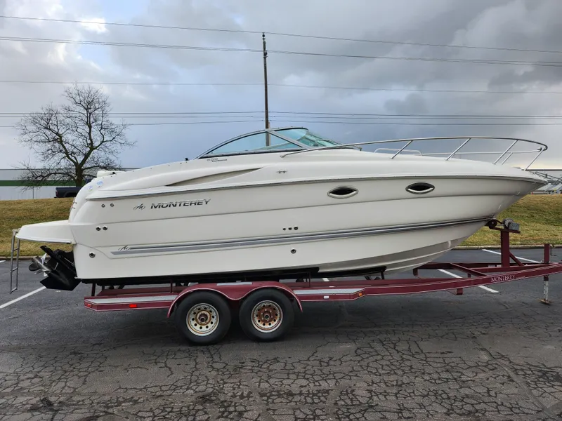 Slide: The Image of 2007 Monterey 250 Cruiser boat on trailer, parked outdoors under cloudy sky. - 4