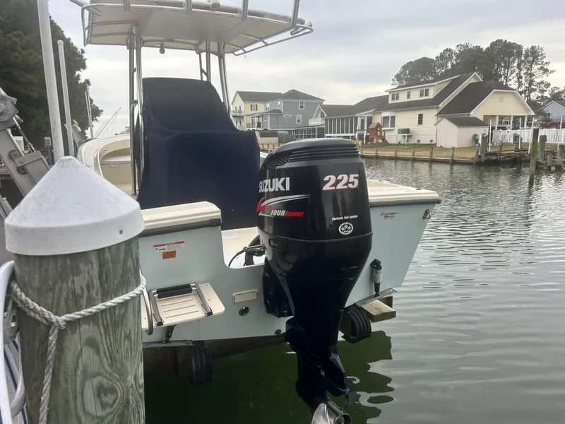 Slide: The Image of Parker 23 Special Edition boat with Suzuki 225 engine docked by waterfront homes. - 2